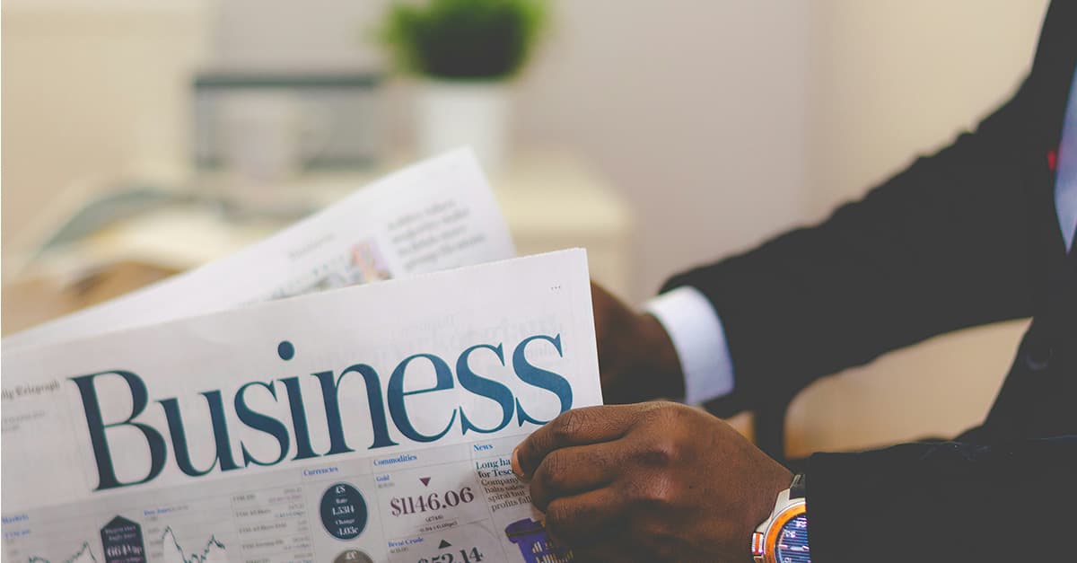 Business man reading the business section of a broadsheet newspaper